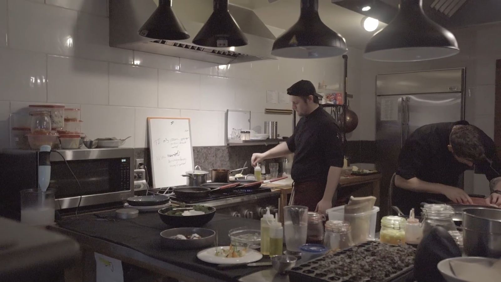 Chefs preparing food in a professional restaurant kitchen